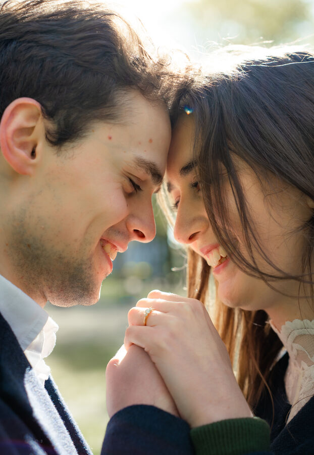 Close-up of an engaged couple forehead to forehead showing the engagement ring