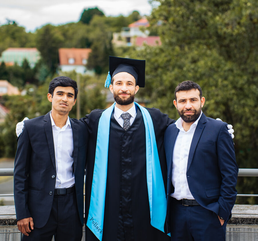 Graduate in cap and stole celebrating with two friends after the ceremony